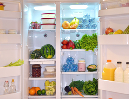 A wide-open fridge stocked with food and drinks.