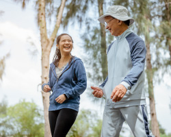 A man and a woman laugh as they go for a walk.