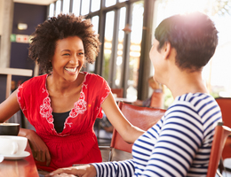 Two women chatting at a café table.