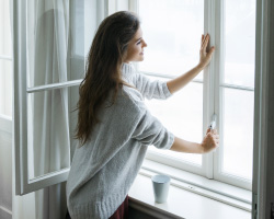 A woman opens a window.