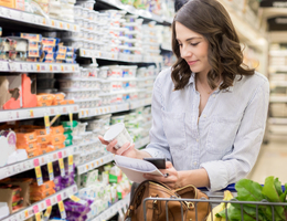 Woman looking at food products on grocery store shelf.