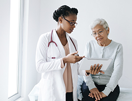 An elderly woman consults with her doctor. 