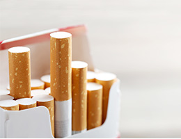 Close-up image of a pack of cigarettes, with several cigarettes sticking up out of the pack. 