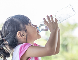 A little girl drinking water.