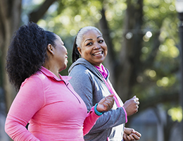 Two middle-aged women walking outside.