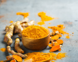 Crushed and whole turmeric and a wooden spoon